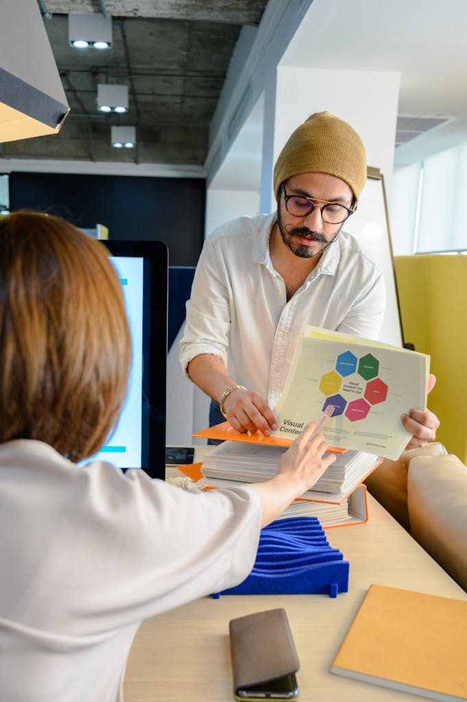 Team members discussing visual data and graphs during an office meeting.